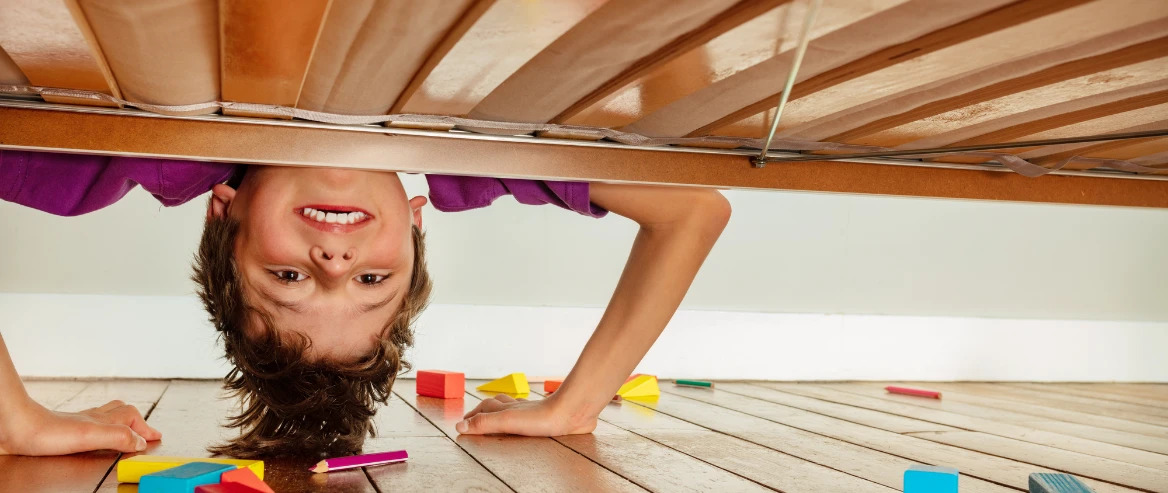 Child Look Under The Bed With Messy Toys