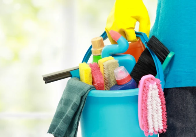 house cleaner holding bucket of cleaning supplies