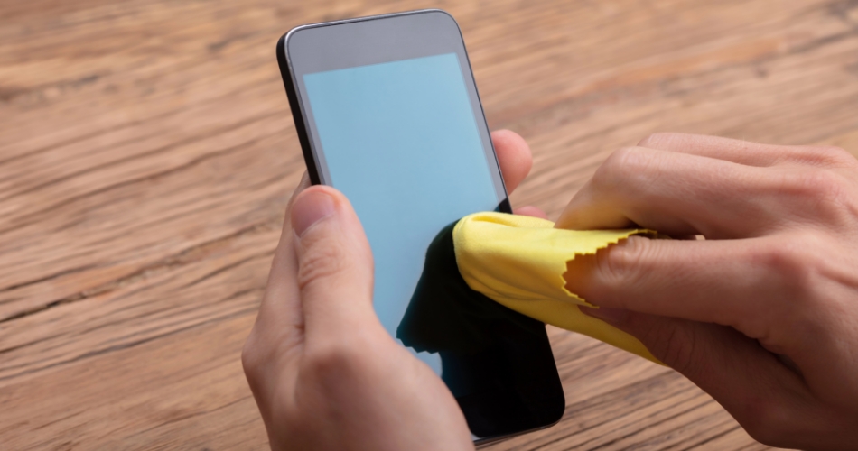 Hand wiping a scratched surface with a soft cloth to reduce light marks.