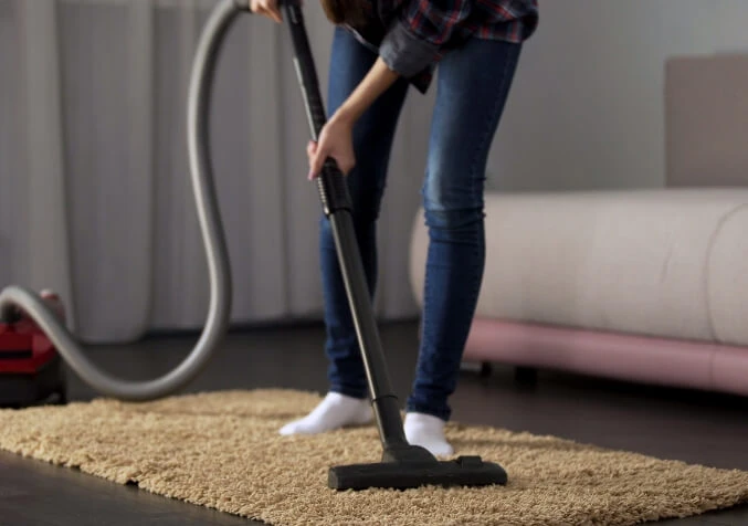 woman vacuuming a rug