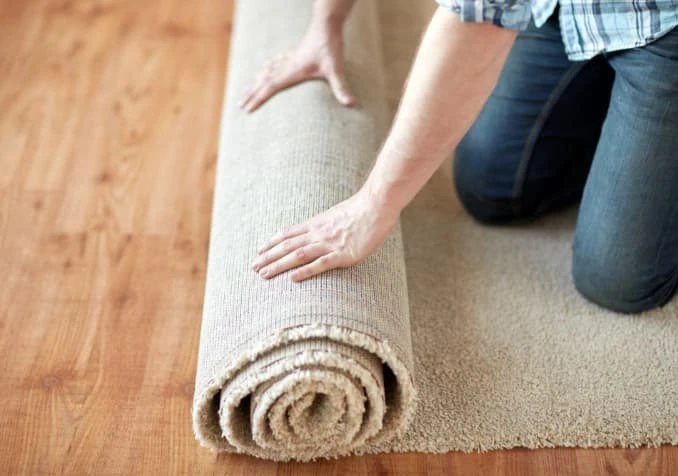 laying rug on wooden floor